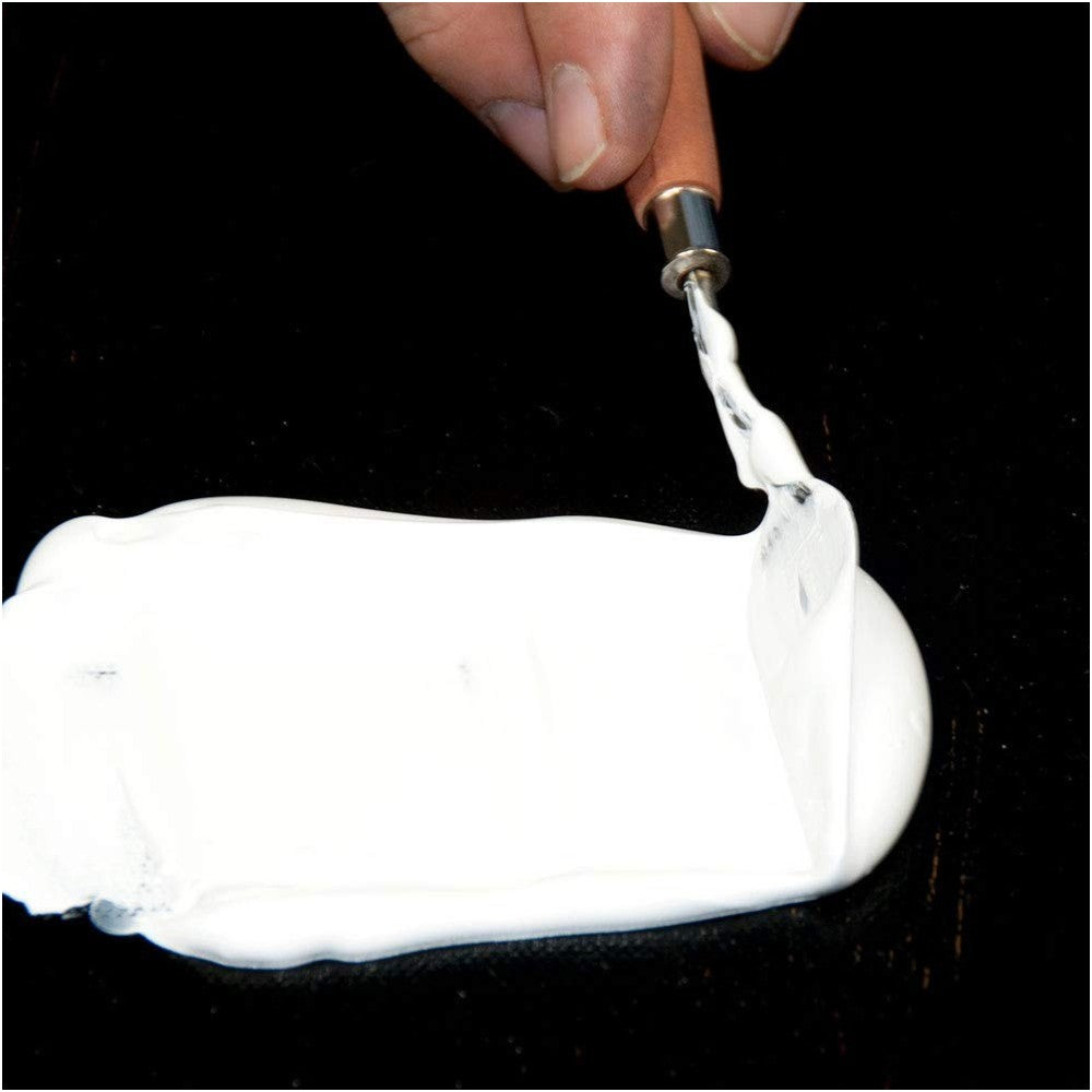 Gesso being applied on canvas using a knife