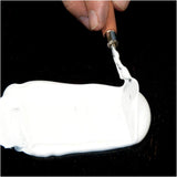 Gesso being applied on canvas using a knife